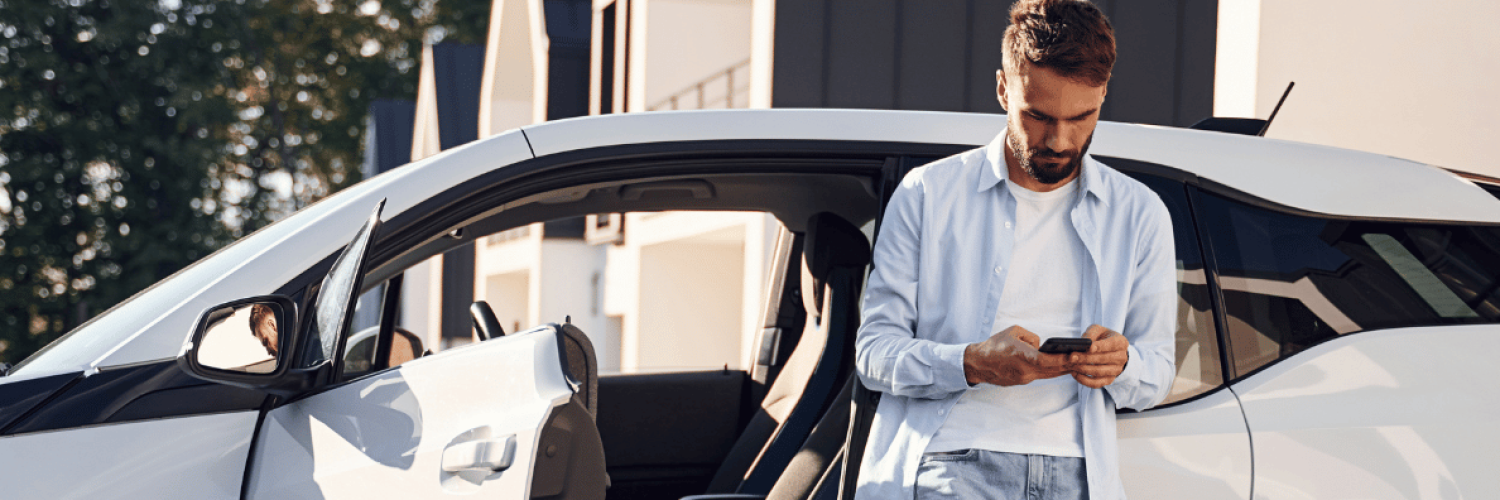 Man leaning up against car with phone in hand Man leaning up against car with phone in hand